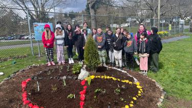 Group of students stand at the newly planted garden