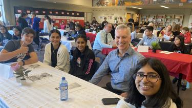 4 students and City of Abbotsford Mayor sitting at a table