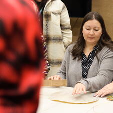 Group of students and staff gathered to learn how to make a drum